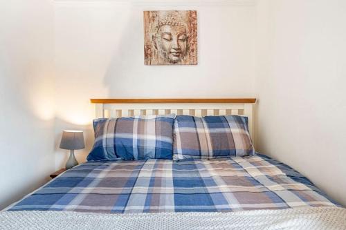 łóżko z poduszką i zdjęciem na ścianie w obiekcie Close to city centre home w mieście Belfast