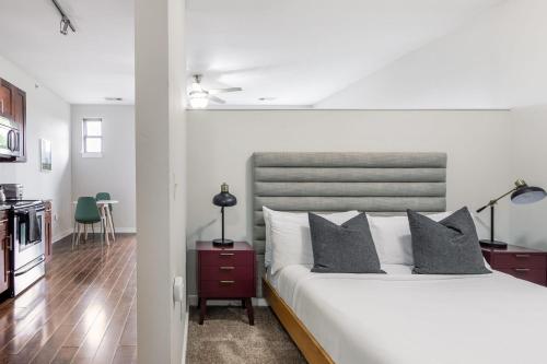 a bedroom with a large white bed with gray pillows at CozySuites MusicRow Astonishing Studio with free parking 52 in Nashville