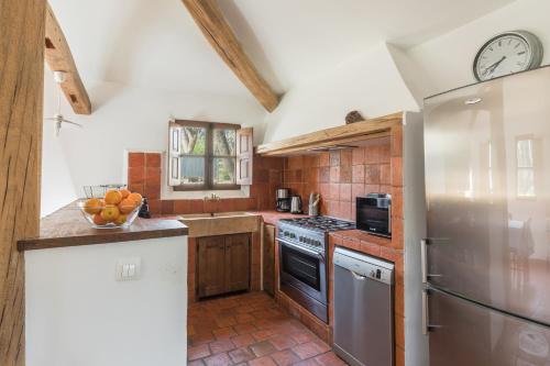 une cuisine avec des armoires en bois et une horloge au mur dans l'établissement Casa di Pruno, à Figari