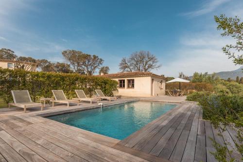 a swimming pool with chairs and a house at Casa di Pruno in Figari