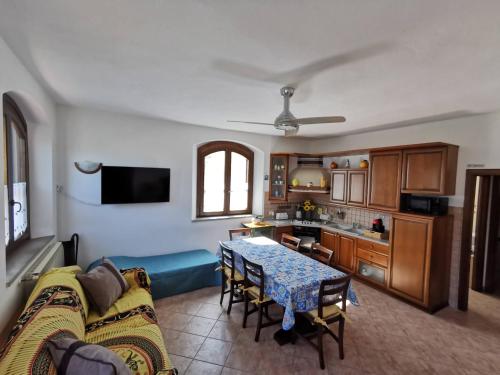 a living room with a table and a kitchen at Le Frasche di Marido holiday apartments in Alberese