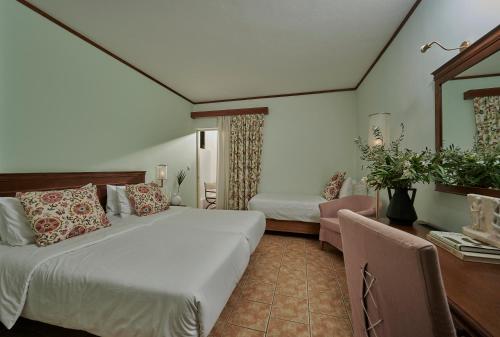 Habitación de hotel con cama grande y escritorio. en Alkyon Resort Hotel & Spa, en Vrachati