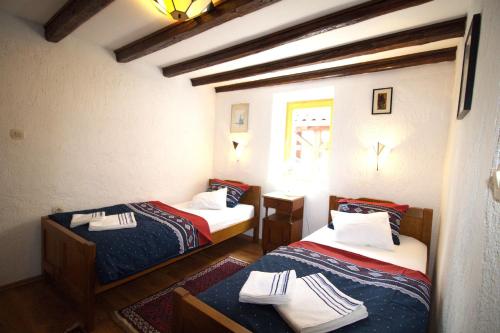 a room with two beds and a window at Beautiful Dalmatian Stone House with swimming pool in Jezera