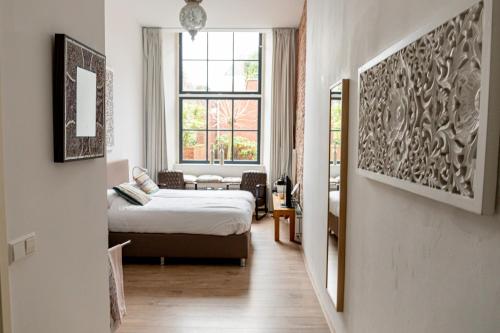 a hotel room with a bed and a window at 1001 Nights Boutique Hotel in Haarlem