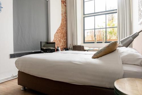 ハーレムにある1001 Nights Boutique Hotelの窓付きの客室で、白い大型ベッド1台が備わります。