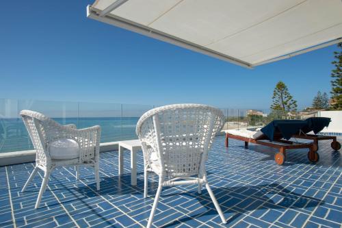 a patio with two chairs and a table and a dog laying on it at B&B Mammaliturchi SCALA DEI TURCHI in Realmonte