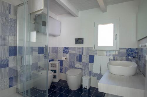 un bagno blu e bianco con lavandino e servizi igienici di B&B Mammaliturchi SCALA DEI TURCHI a Realmonte