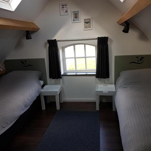 a bedroom with two beds and a window at De Oude Koeienstal in Schimmert