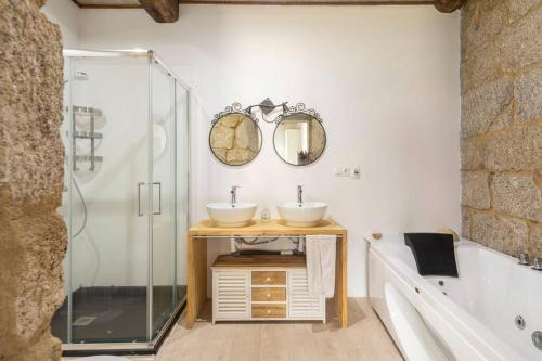 un bagno con due lavandini e una doccia in vetro di Casa en Dozón Centro de Galicia 