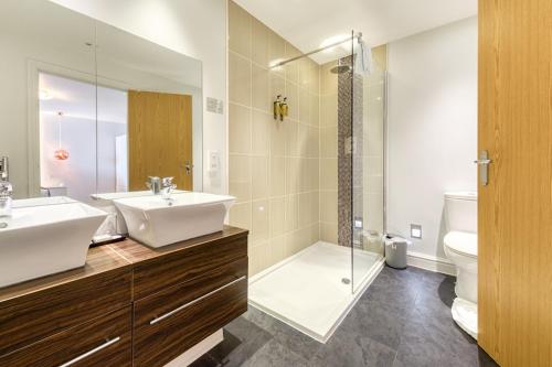 a bathroom with a sink and a shower and a toilet at Sandy Cove Hotel in Ilfracombe