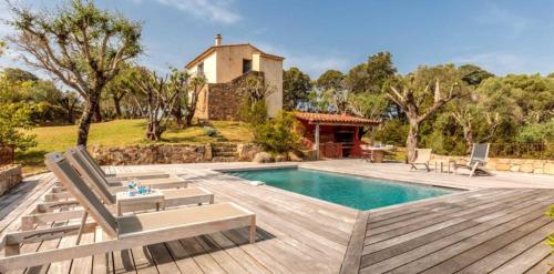 une arrière-cour avec une piscine, des chaises et une maison dans l'établissement Villa Bicu Rossu, à Figari