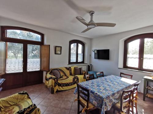 a living room with a table and a ceiling fan at Le Frasche di Marido holiday apartments in Alberese