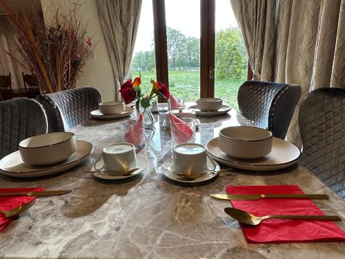 a table with plates and cups on top at Barnfields Retreat in Little Clacton