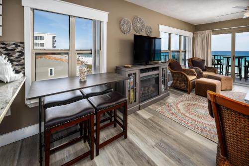 uma sala de estar com televisão e uma sala de estar com o oceano em Emerald Twrs West 4000 by Brooks and Shorey Resorts condo em Fort Walton Beach