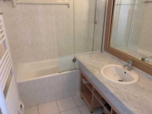 un bagno con lavandino, doccia e vasca di Appartement dans résidence de standing avec terrasse et vue mer a Le Pouliguen