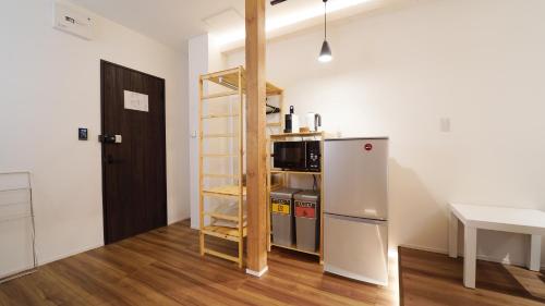 a small kitchen with a refrigerator and a ladder at THE LOBS, RUSUTSU in Kimobetsu