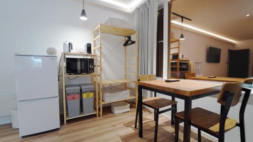 a small kitchen with a table and a refrigerator at THE LOBS, RUSUTSU in Kimobetsu