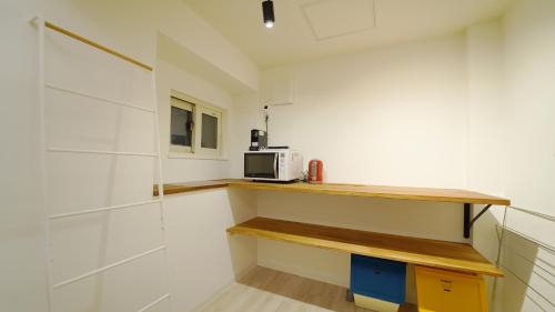 a kitchen with a counter and a microwave on a shelf at THE LOBS, RUSUTSU in Kimobetsu
