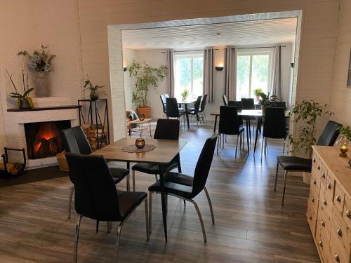 a dining room with a table and chairs and a fireplace at Brinkeboda Wärdshus in Mörsil