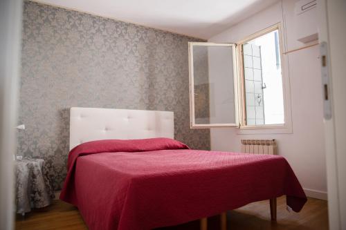 a bedroom with a bed with a red blanket at San Maurizio Apartment in Venice