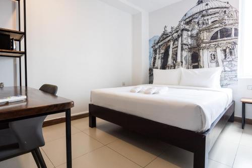 a hotel room with a bed and a desk at Times Hotel at Bassac Lane in Phnom Penh