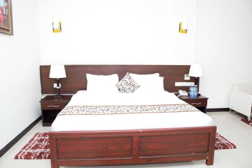 a bedroom with a large bed with two night stands at Hotel Blue Sapphire in Dar es Salaam