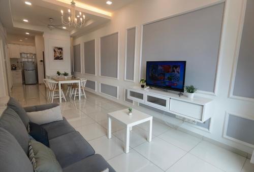 ein Wohnzimmer mit einem Sofa und einem Flachbild-TV in der Unterkunft D’Summit residences, Setia tropika , Johor Bahru in Johor Bahru