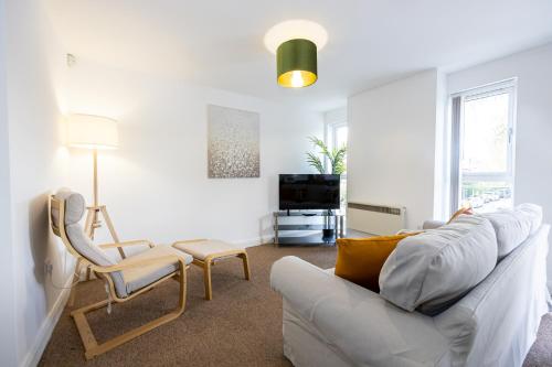 a living room with a white couch and a chair at The Chorlton in Manchester