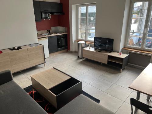 - une cuisine avec un salon doté d'un canapé et d'une table dans l'établissement 1 appartement neuf centre flers accès facile proche gare et commodités, à Flers