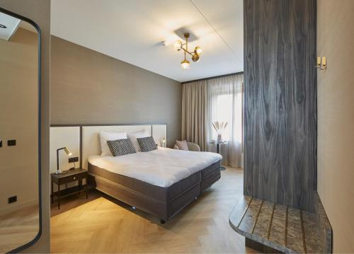 una camera con un grande letto di Breathe Hotel Leiden a Leida