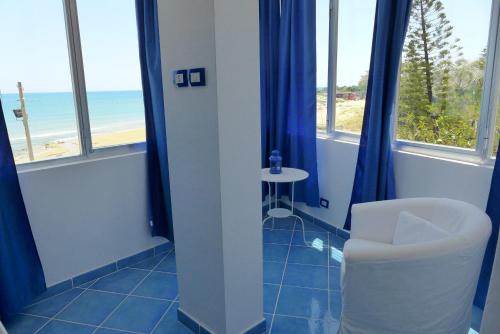 a bathroom with a toilet and a table and windows at B&B Mammaliturchi SCALA DEI TURCHI in Realmonte