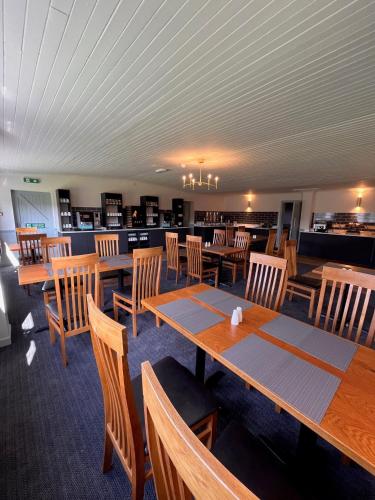 a dining room with wooden tables and wooden chairs at Beaufort Park Hotel in Mold