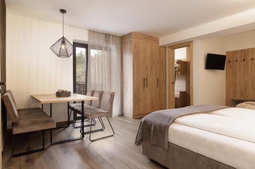 a bedroom with a bed and a desk and a table at Aparthotel Familiaris - Family Apartments - Pools & Spa in Dolomites in Valdaora