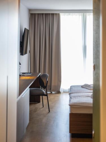 a hotel room with a desk and a bed at Hotel Villa Rosetta in Savudrija
