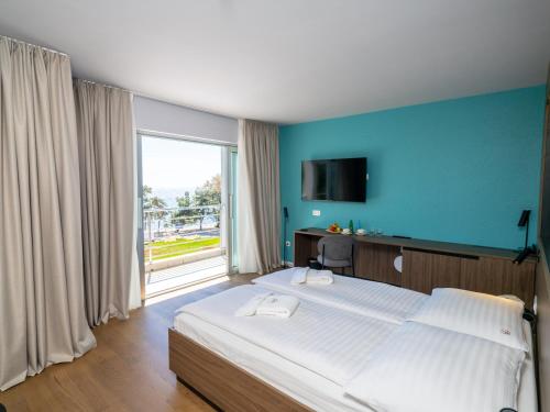 a bedroom with a large bed and a large window at Hotel Villa Rosetta in Umag