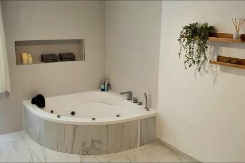 a white bath tub in a white room at נווה שחר - יחידת נופש עם ג'קוזי פרטי ובריכה משותפת באזור כפרי ליד טבריה in Poriyya