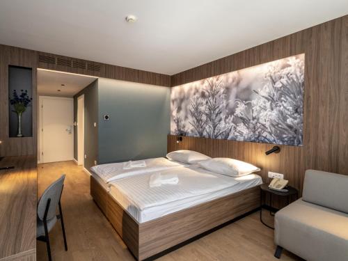 Hotel Villa Rosetta في أوماغ: غرفة نوم بسرير ودهان على الحائط