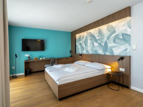 a bedroom with a bed with a painting on the wall at Hotel Villa Rosetta in Savudrija