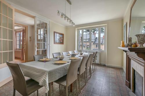 une salle à manger avec une table et des chaises et une cheminée dans l'établissement Échappée familiale à deux pas de la plage, au Pouliguen