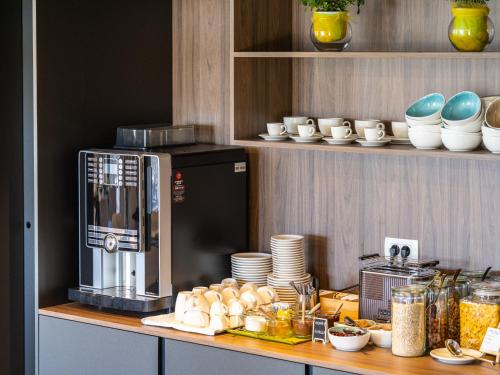 a kitchen with a counter with a coffee maker and dishes at Hotel Villa Rosetta in Savudrija