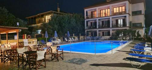 a hotel with a swimming pool in front of a building at Christina Studios in Lygia