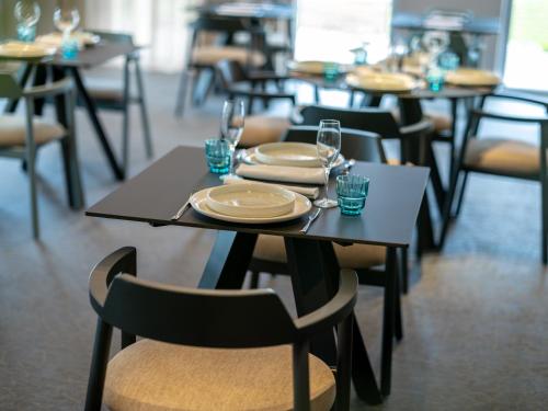 a table with plates and glasses on it in a restaurant at Hotel Villa Rosetta in Savudrija