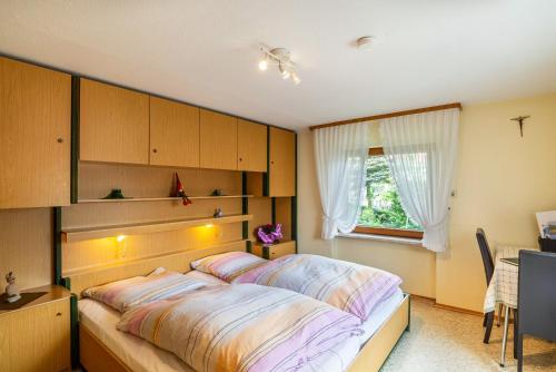 1 dormitorio con cama, escritorio y ventana en Bergblick en Forbach