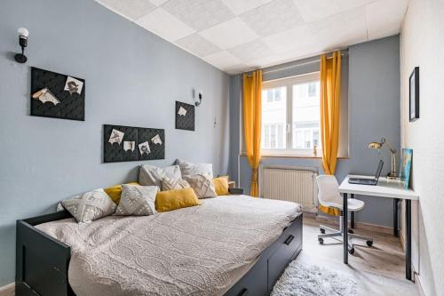 Un dormitorio con una cama, un escritorio y una computadora. en Le City Center spacieux et chic, en Saint-Étienne