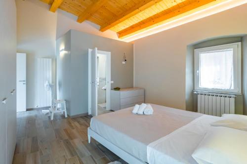 ein Schlafzimmer mit einem großen weißen Bett und einem Fenster in der Unterkunft Comfy & Roomy Apt - View on the Ligurian Hills! in Vezzano Ligure