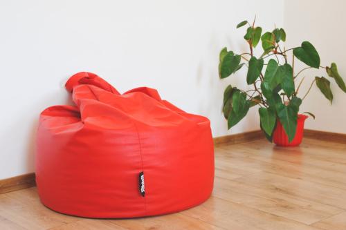 a red couch sitting on the floor next to a plant at Apartmán Rybná - Kraslice in Kraslice