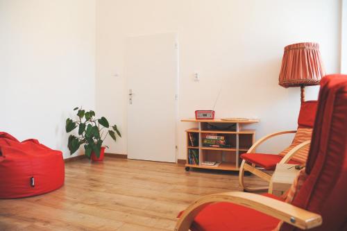 a living room with a red chair and a table at Apartmán Rybná - Kraslice in Kraslice