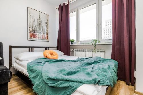 a bedroom with a bed with a green blanket at ShortStayPoland Jasna (B127) in Warsaw