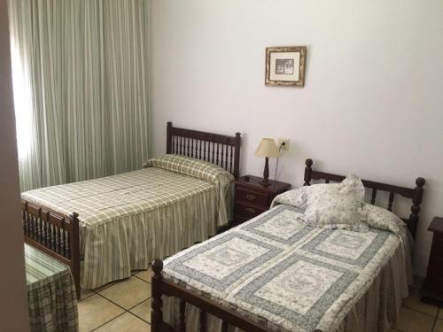 um quarto com 2 camas e uma mesa com um candeeiro em Cortijo de Lorente Alojamiento Turístico Rural -Teba -Malaga em Teba