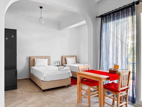 - une chambre avec 2 lits, une table et un bureau dans l'établissement Kaş Merkezde Konforlu Apart-3 The Rush-3, à Kaş